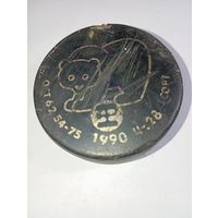 Коллекционная хоккейная шайба времен СССР, выпущенная в 1990 году. На ней изображен медвежонок (возможно, вариация олимпийского Мишки или символ турнира тех лет).