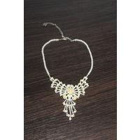 Пластиковое колье с металлической подвеской.