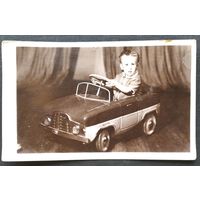 Фото мальчика на педальной машинке. 9х14 см.